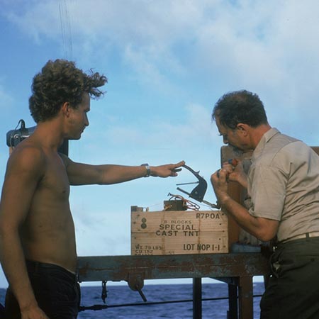 George G. Shor (right) and Robert Marinerb Kieckhefer making up explosives charge, onboard R/V Thomas Washington, Indopac Expedition. July 13, 1976