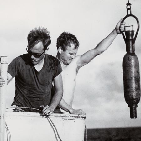 Steven Oboler, Thomas M. Church, and Robert Brennen on Argo carrying a gravity core on deck